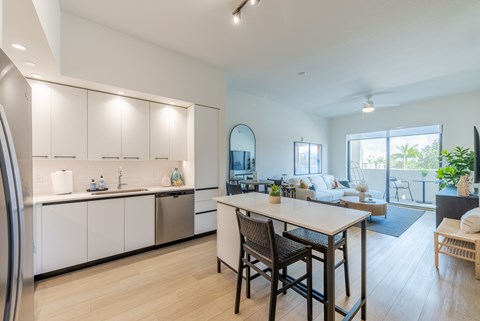 A modern kitchen with a dining table and chairs.