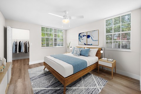 A bedroom with a bed, nightstand, and a painting on the wall.