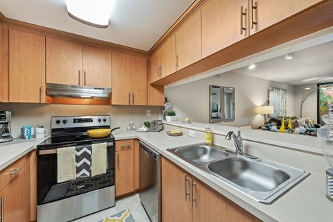 a kitchen with white counter tops and wooden cabinets