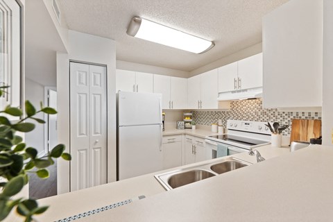 a white kitchen with white appliances and white cabinets