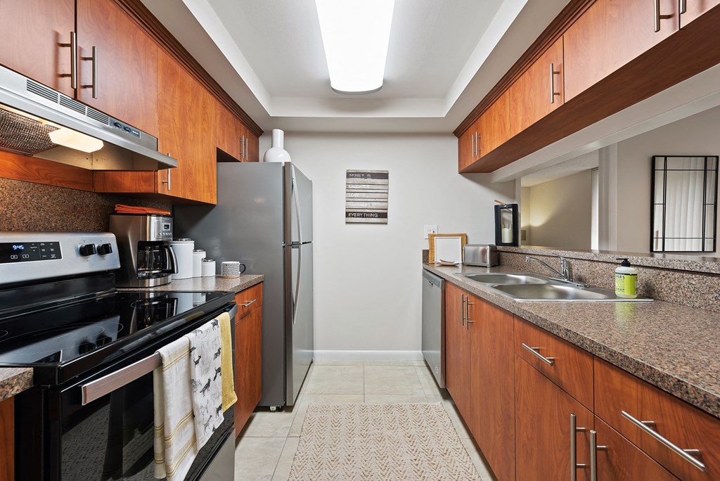 a kitchen with granite counter tops and a stainless steel refrigerator