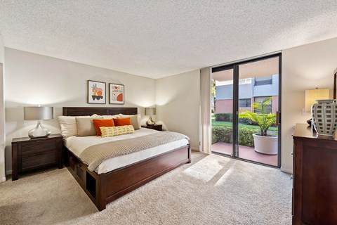 a bedroom with a bed and a sliding glass door
