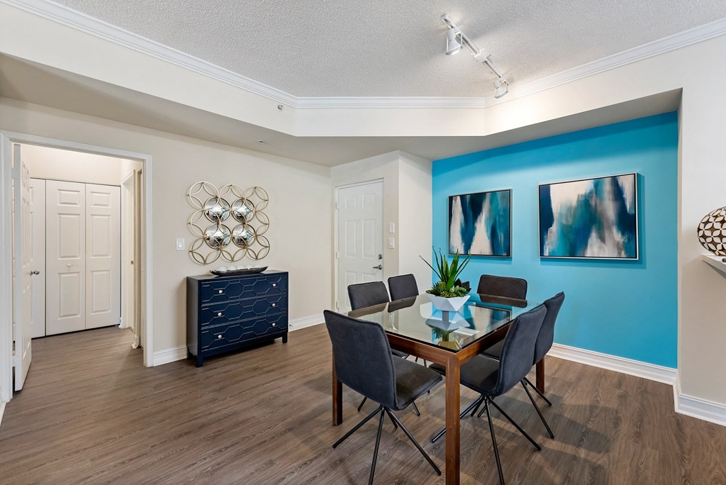 a dining room with a table and chairs and a blue accent wall