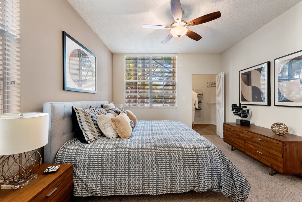 the master bedroom has a large bed and a ceiling fan