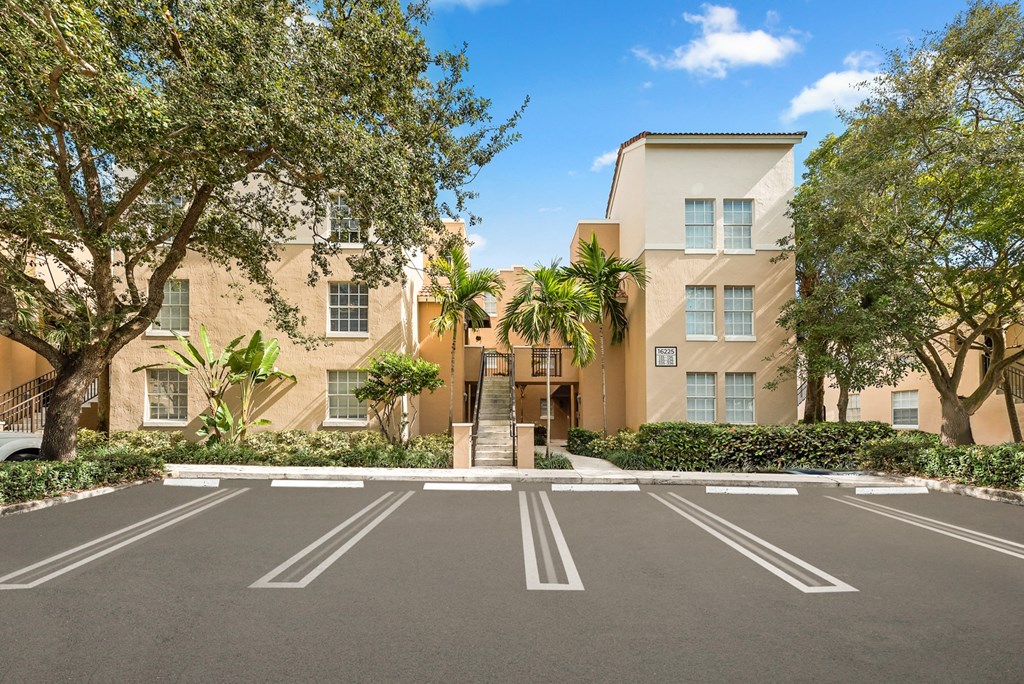 an empty parking lot in front of an apartment building
