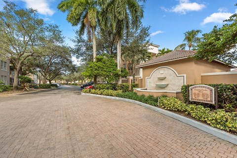 a house with a brick driveway and a sign on the side of it