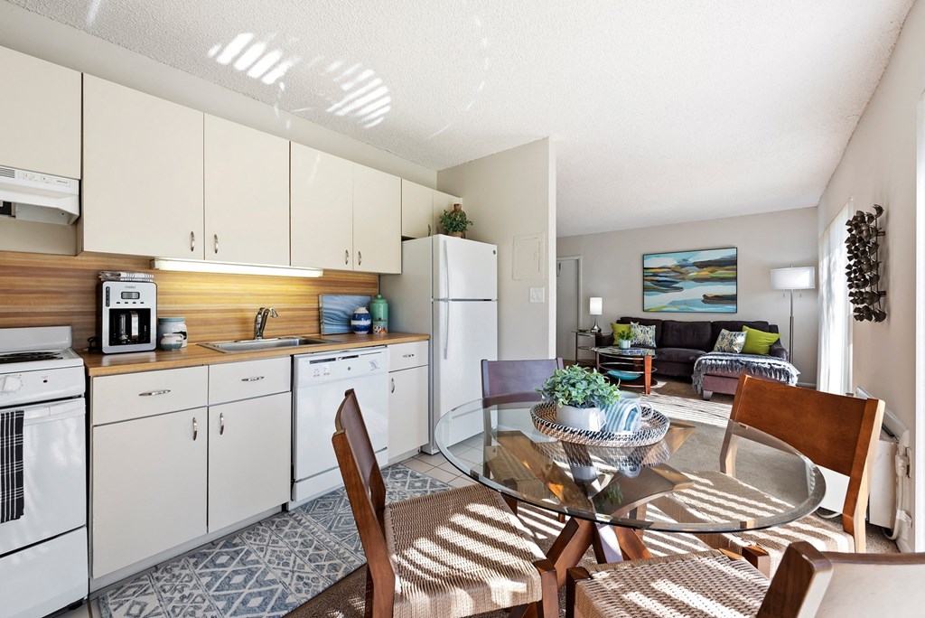 a kitchen and living room with a glass table and chairs