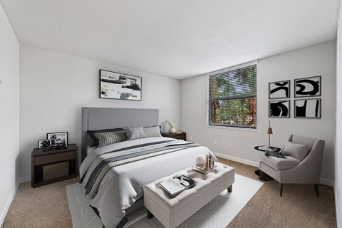a bedroom with a bed and a chair and a window