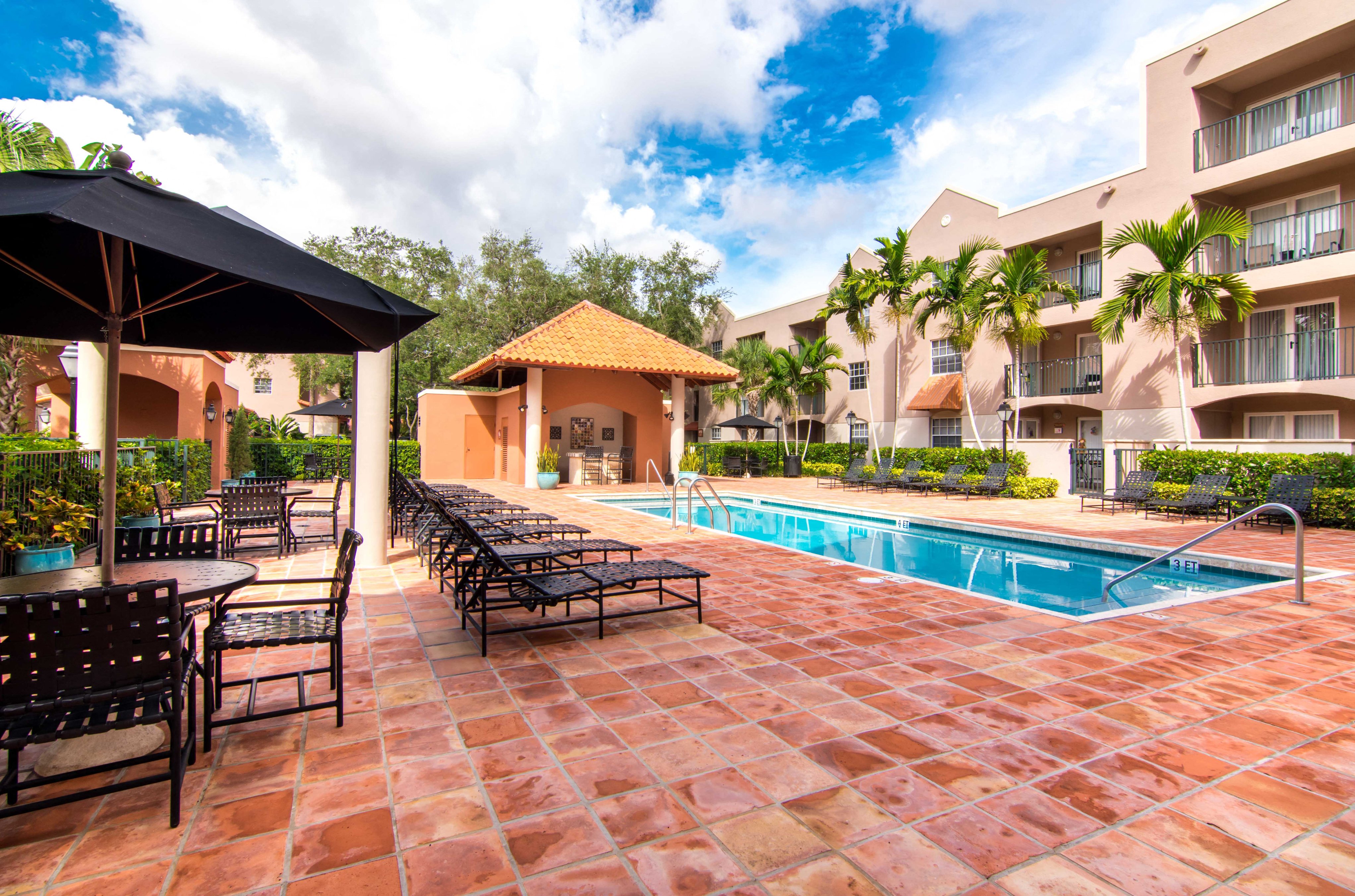 a swimming pool with chairs and umbrellas at a resort