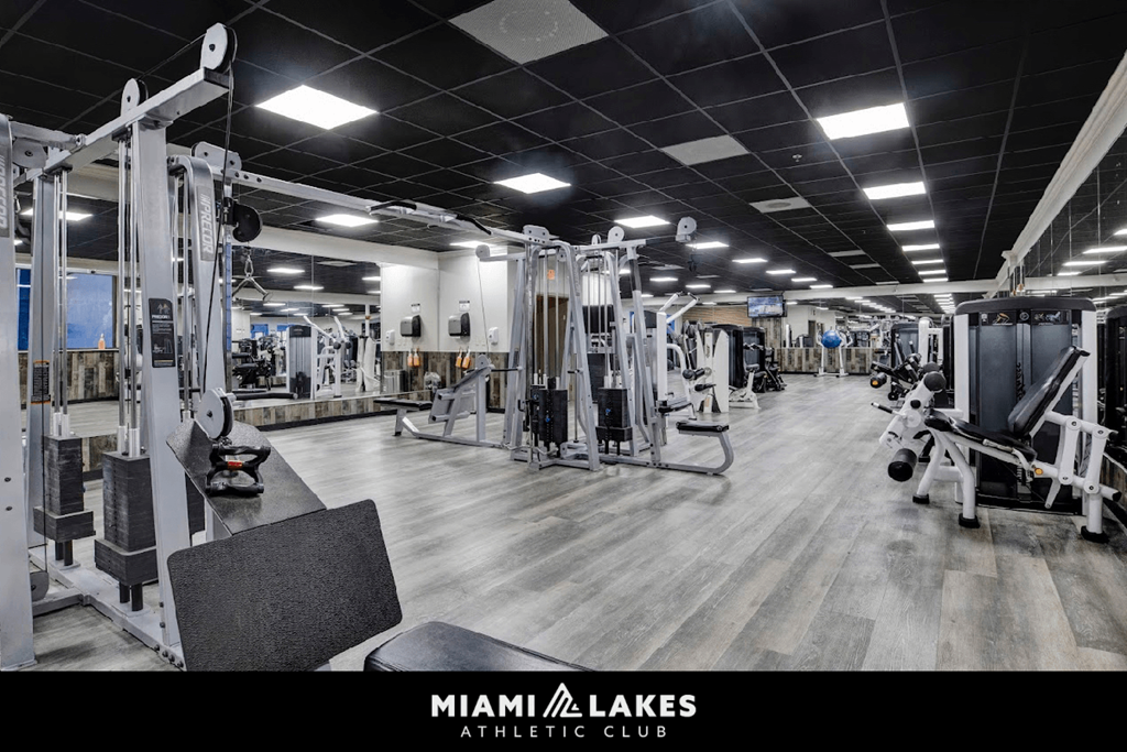A gym with a variety of equipment inside the Miami Lakes Athletic Club.