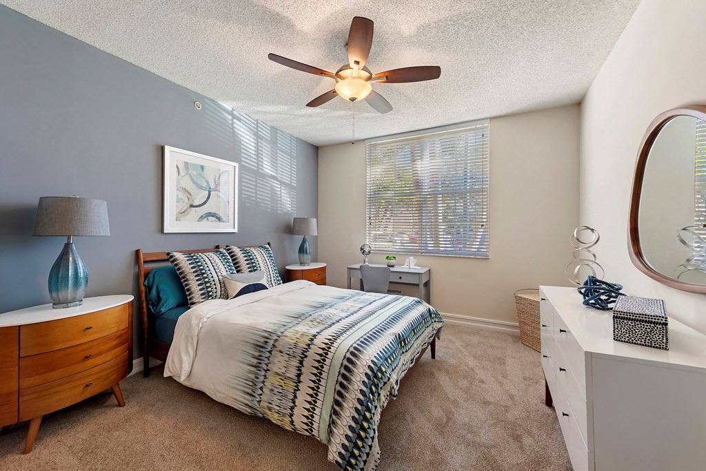 a bedroom with a bed and a ceiling fan