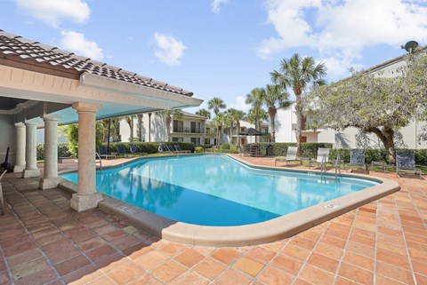 a large swimming pool in front of a house with palm trees