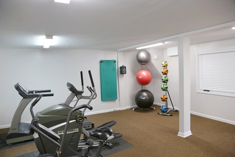 a gym with exercise equipment and a yoga ball on the floor