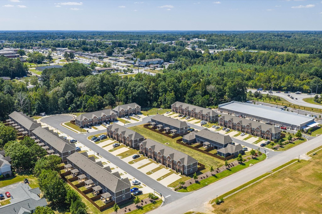 A bird's eye view of a residential area with houses and a parking lot.