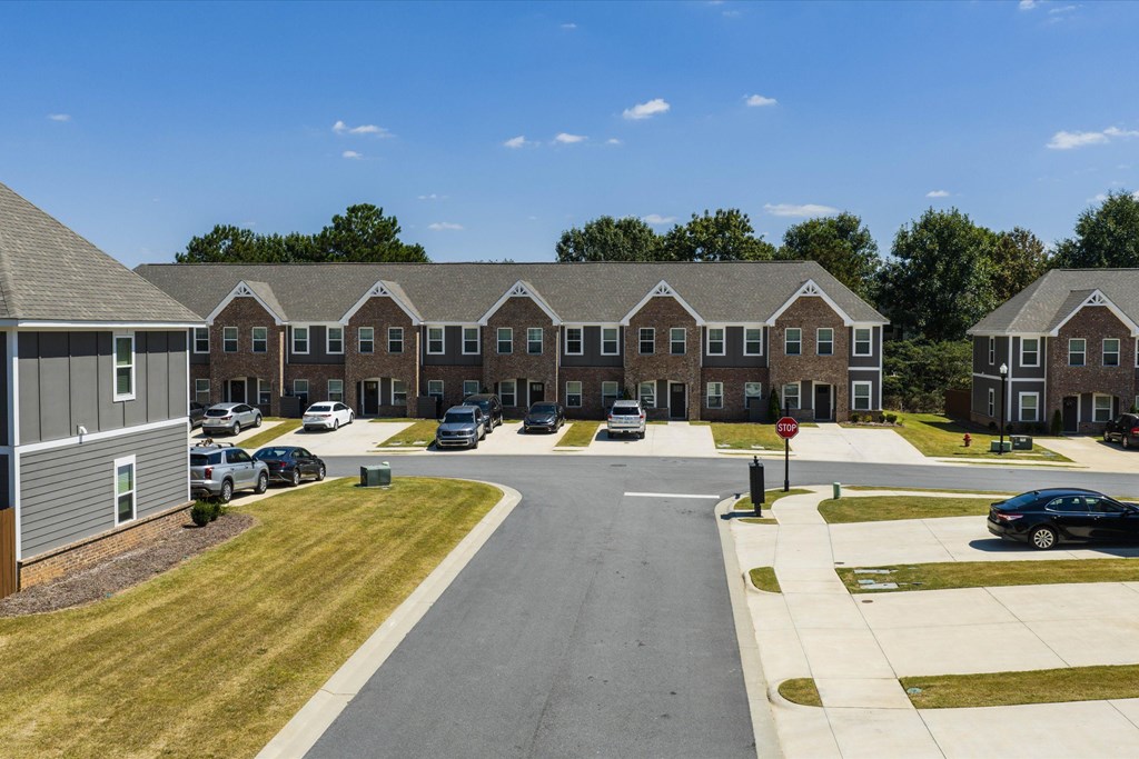 A road leads to a building with a stop sign on the side.