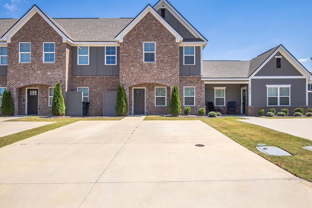 A large brick house with a driveway in front.