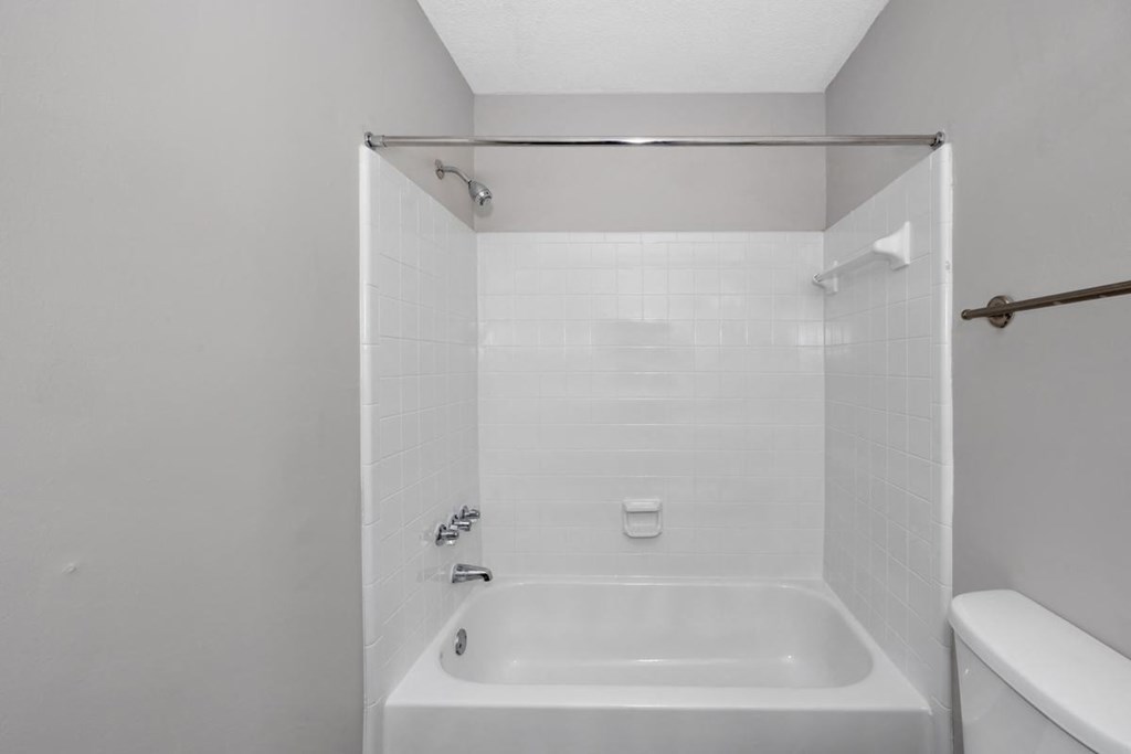 A white bathroom with a tub and shower.