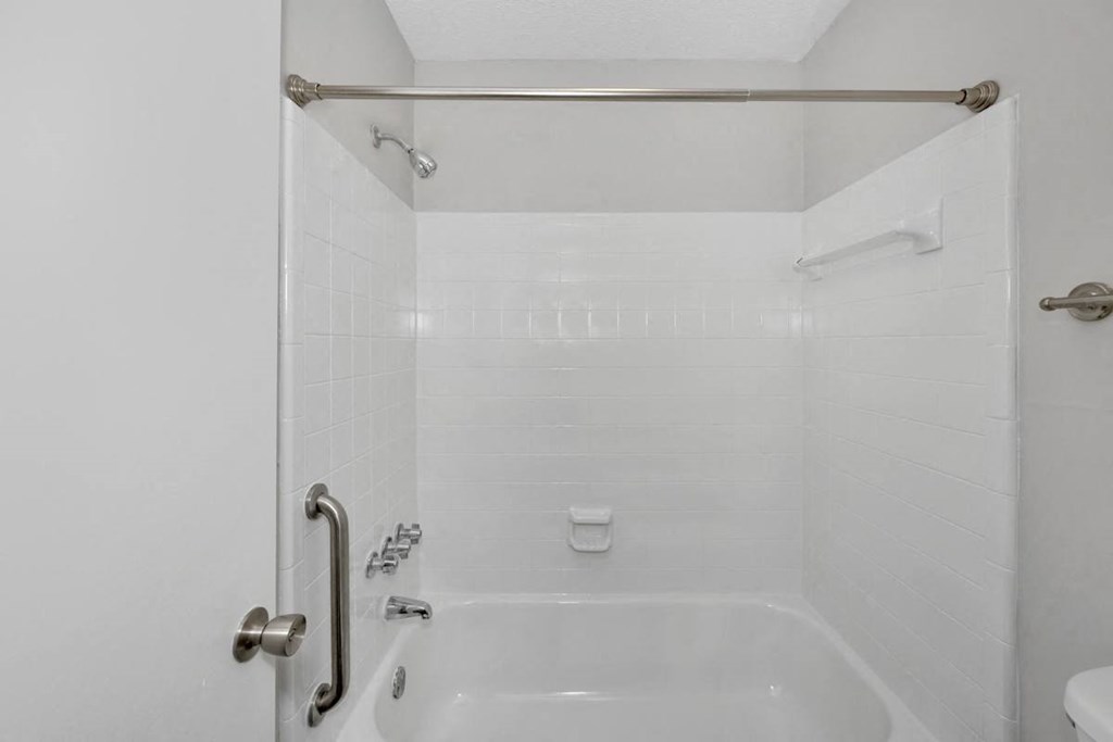 A white bathroom with a tub and shower.