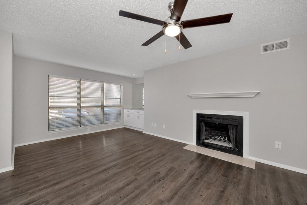 A room with a fireplace and a ceiling fan.