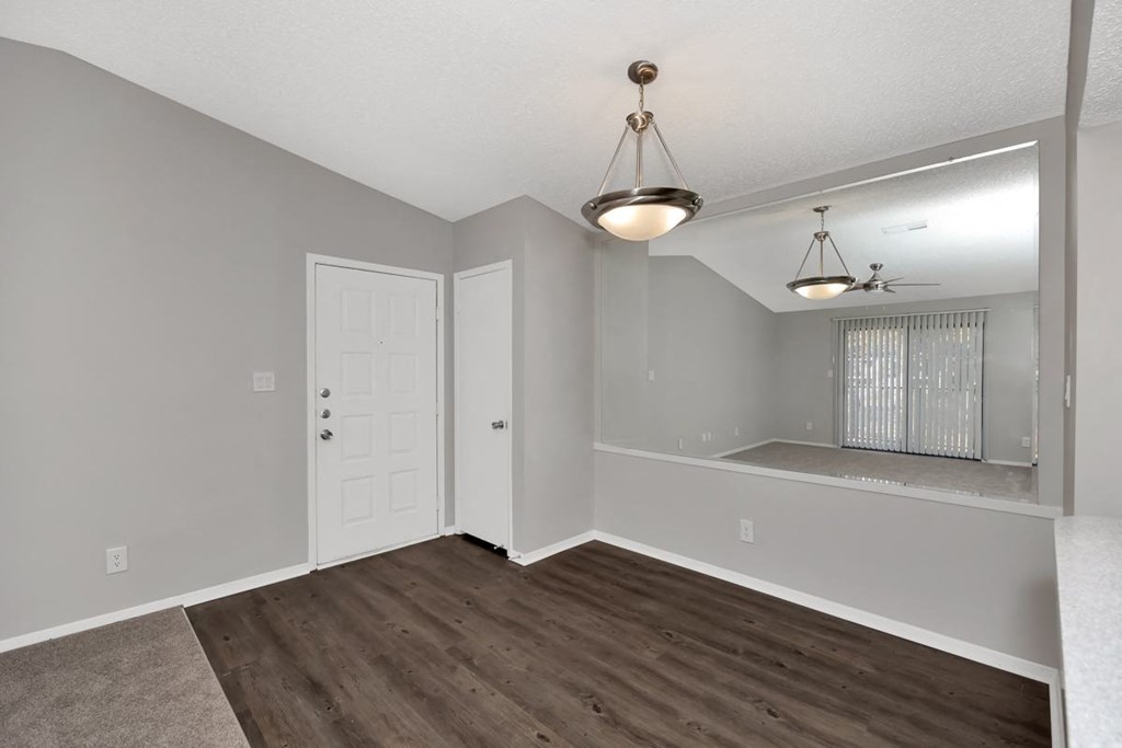 A room with a wooden floor and a hanging light fixture.