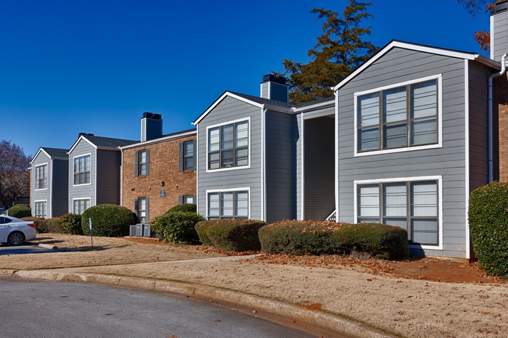A row of houses with a car parked in front of them.