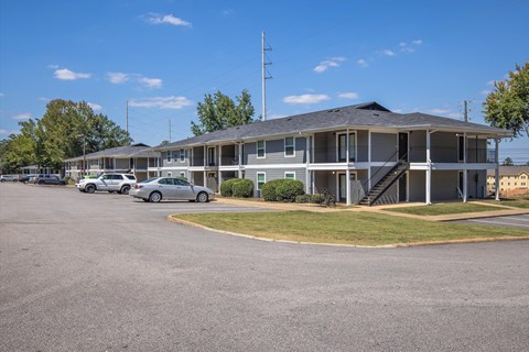 A parking lot with cars and a building in the background.