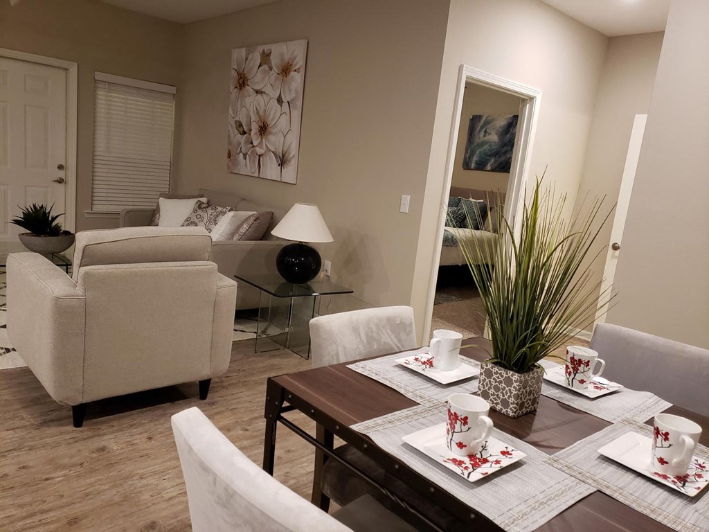 a living room and dining room with a table and chairs