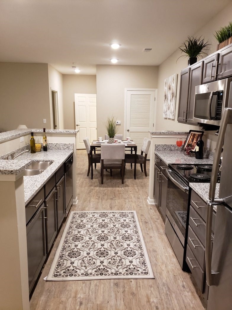 a kitchen and dining room with stainless steel appliances and granite counters