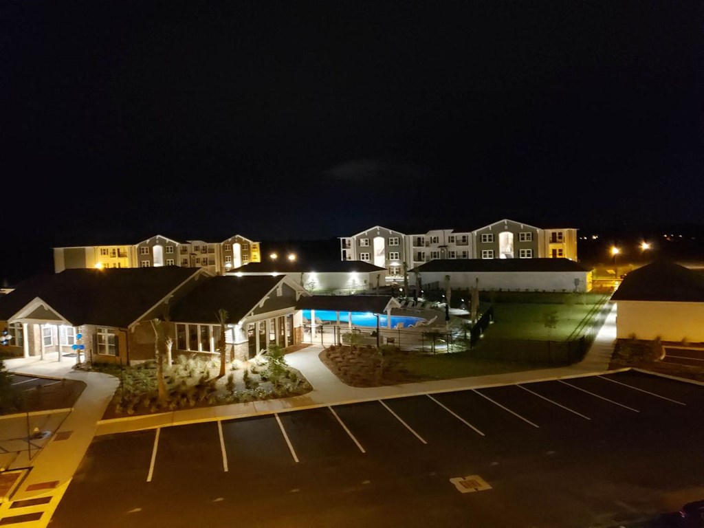 a night view of a resort at night with a swimming pool