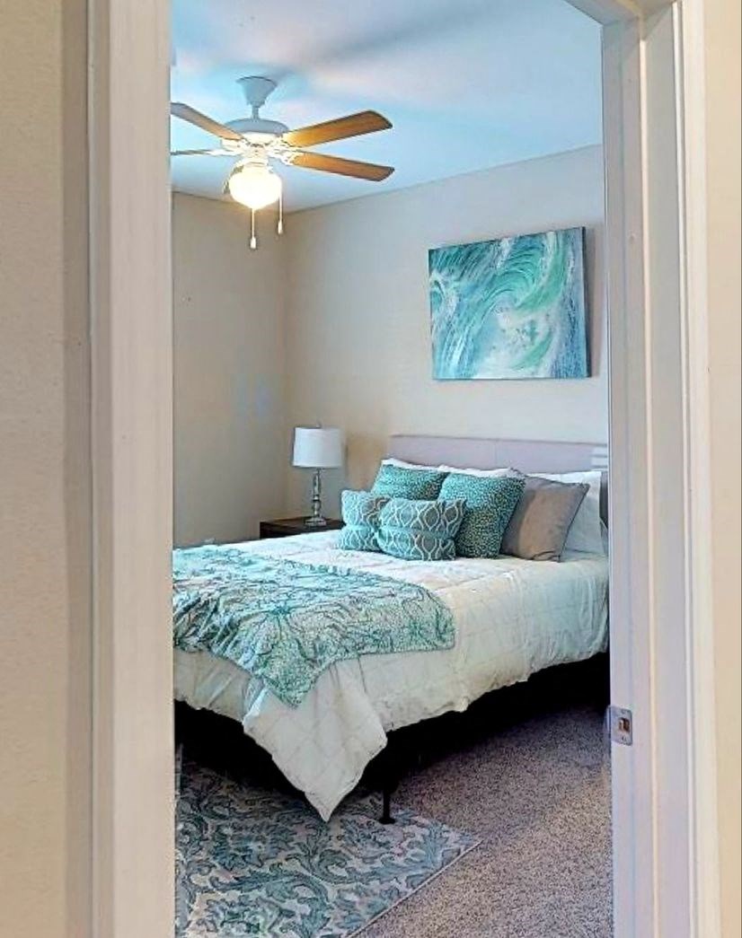 a bedroom with a bed and a ceiling fan