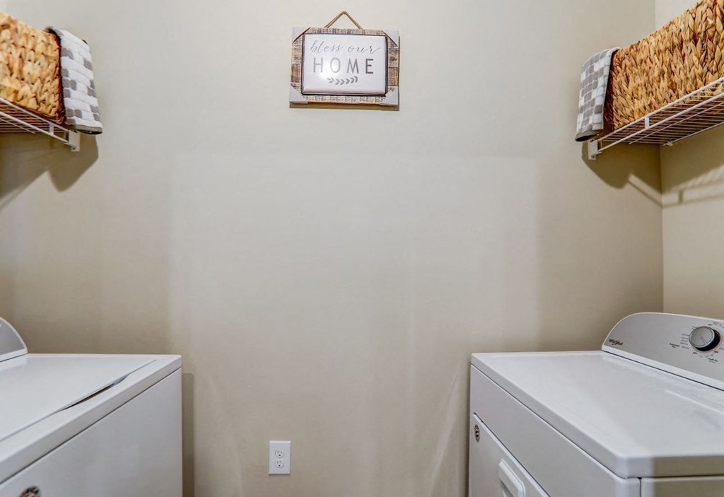a washer and dryer in a laundry room with a sign on the wall
