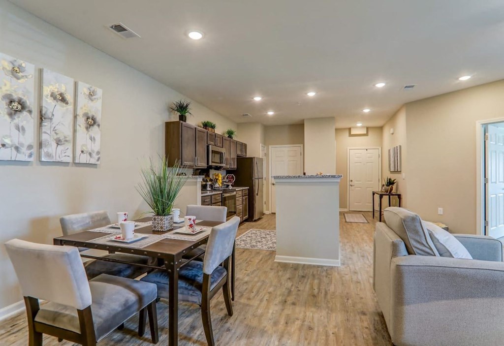 a living room and kitchen with a table and chairs