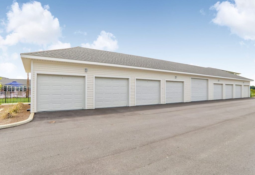 a white garage with white doors on the side of a street