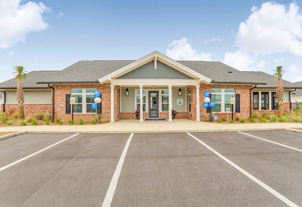 the front of a brick building with balloons in the parking lot