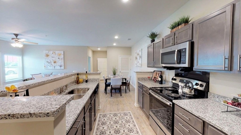 a large kitchen with granite counter tops and stainless steel appliances