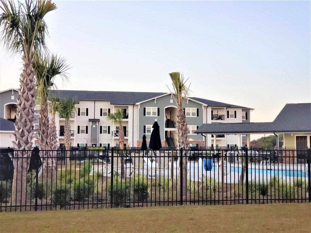 a building with a pool and a fence in front of it