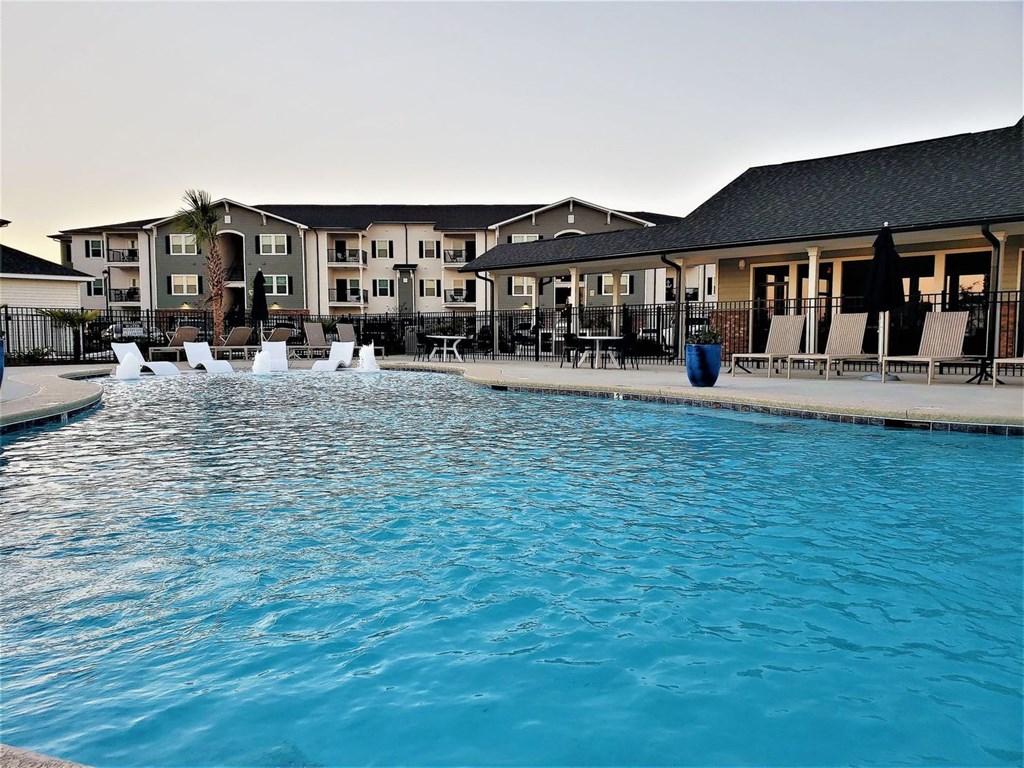 a large swimming pool with a building in the background