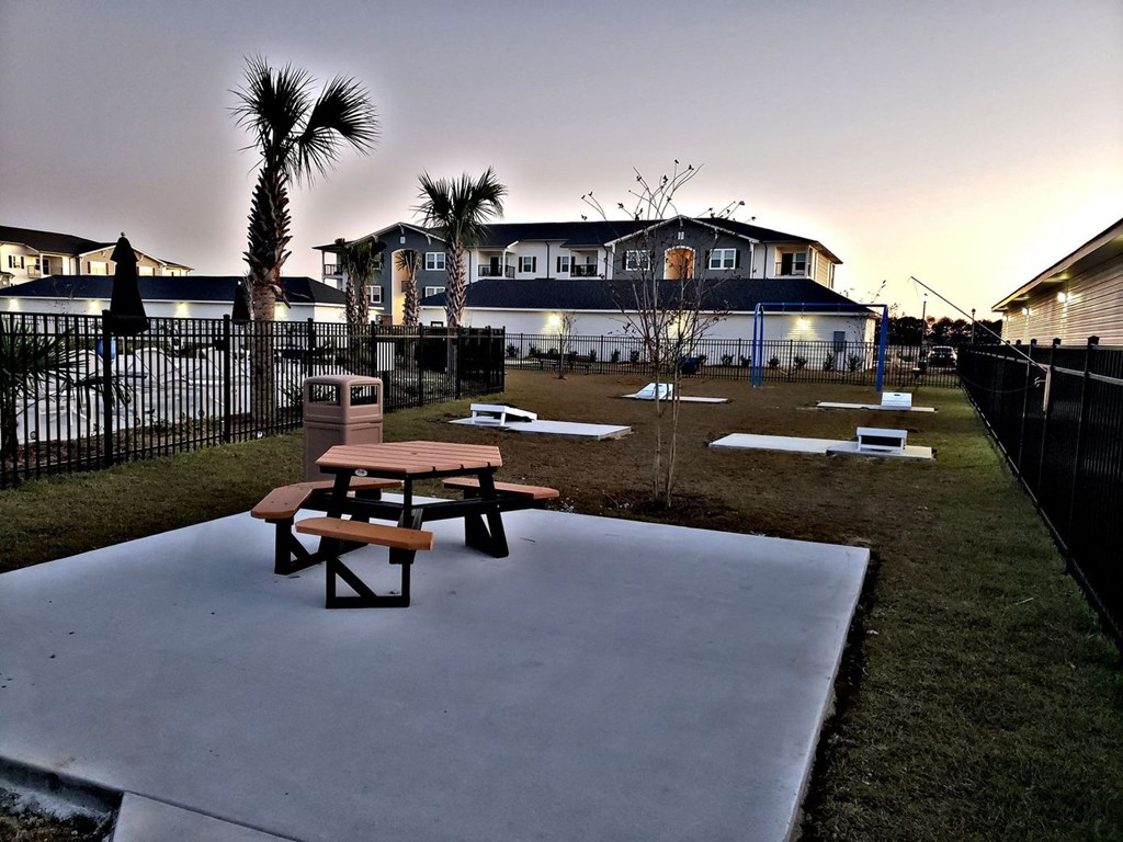 a picnic area with benches in front of a house