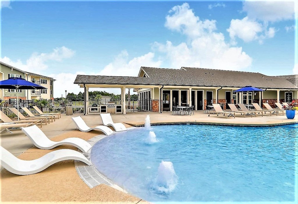 a large swimming pool with chairs and umbrellas in front of a house