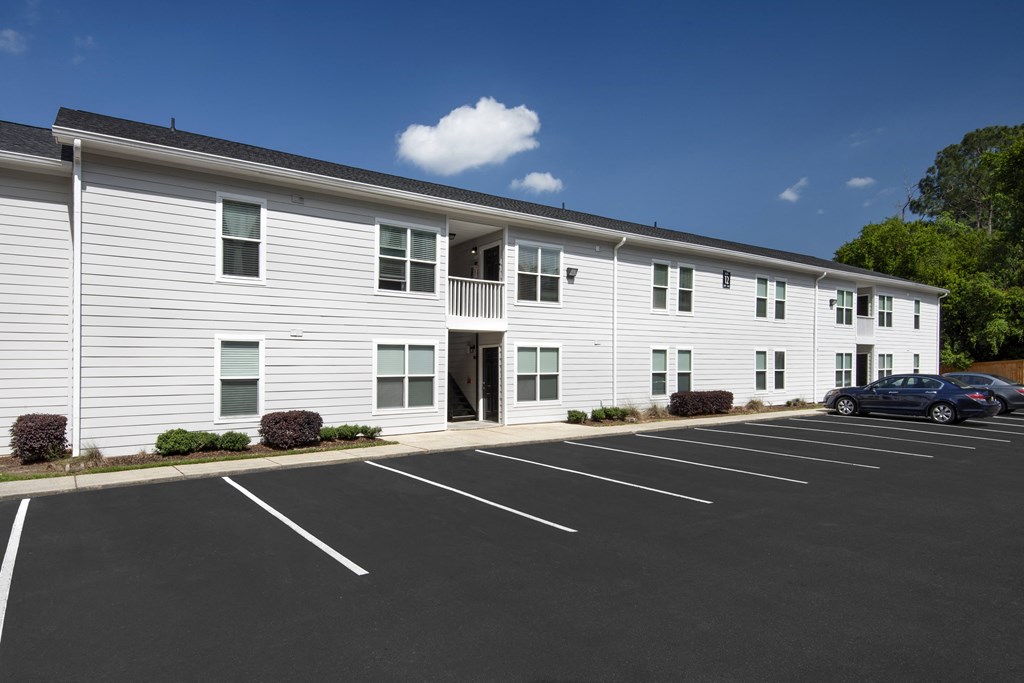 a large white building with a car parked in front of it