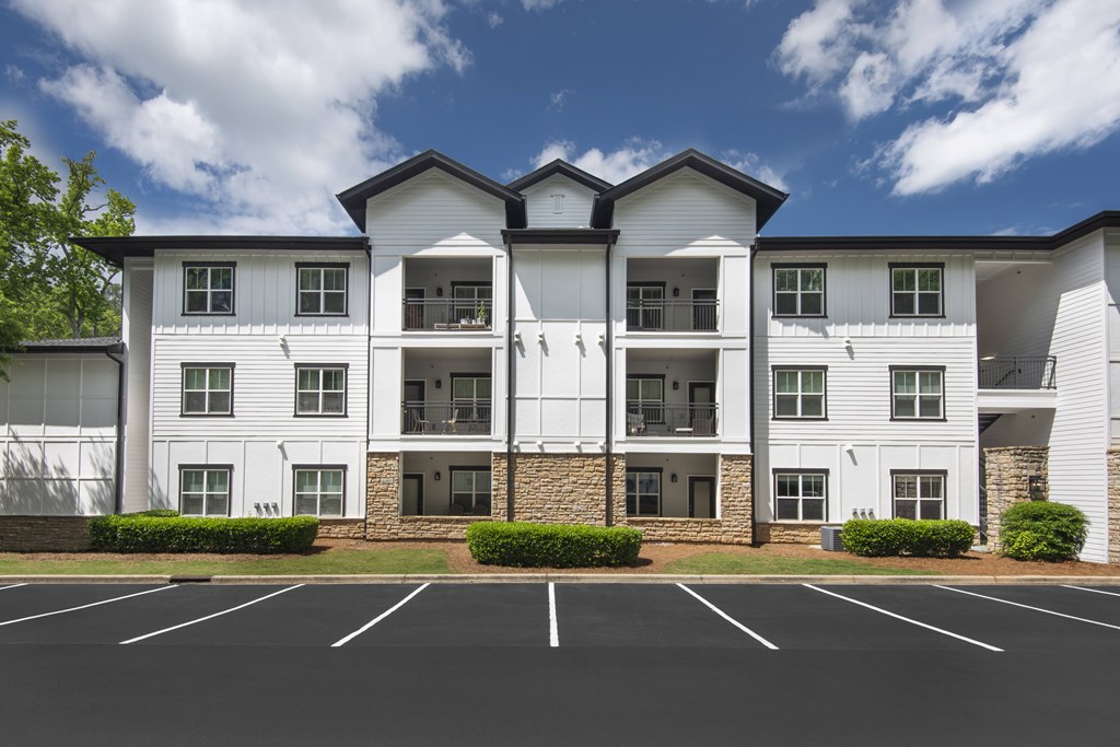 A large white building with a parking lot in front.