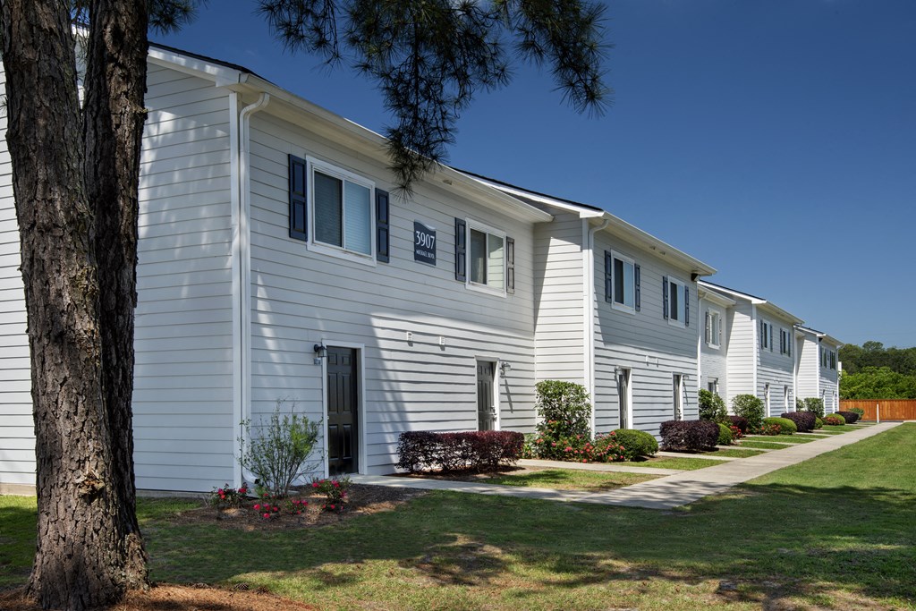 a white house with a tree in front of it