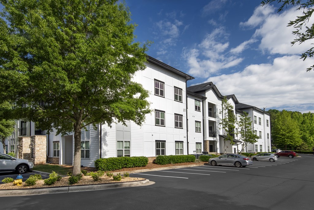 A white building with a parking lot in front.