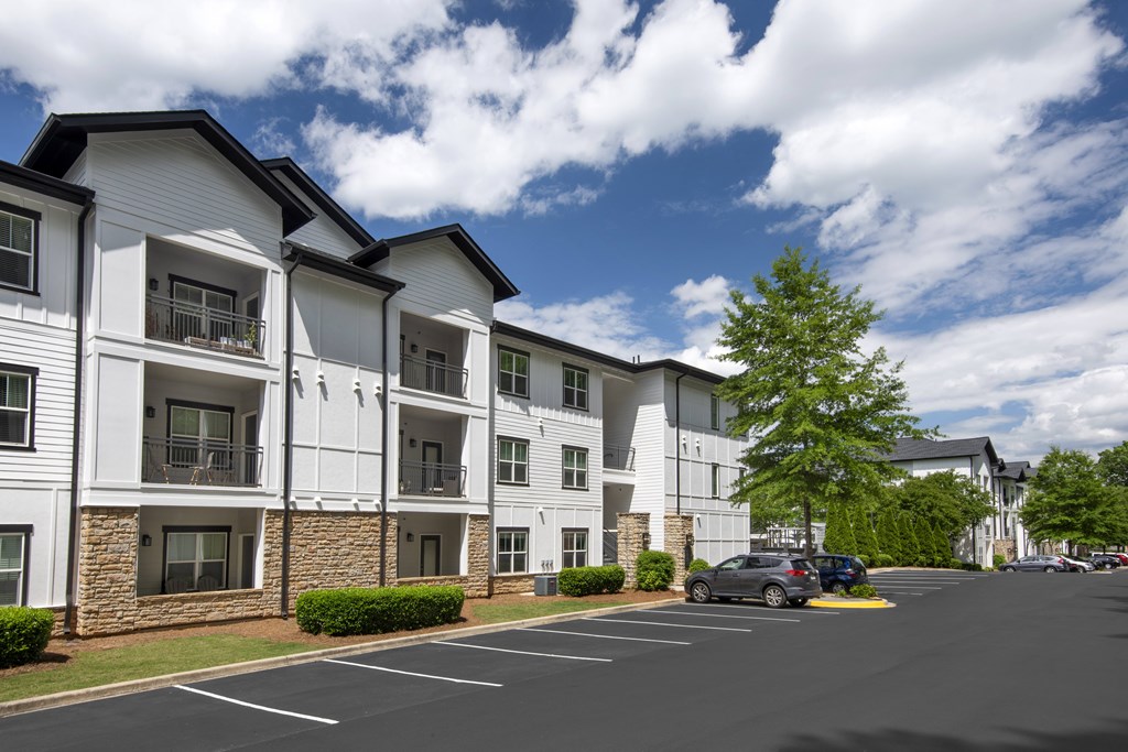 Apartment building with a parking lot in front.