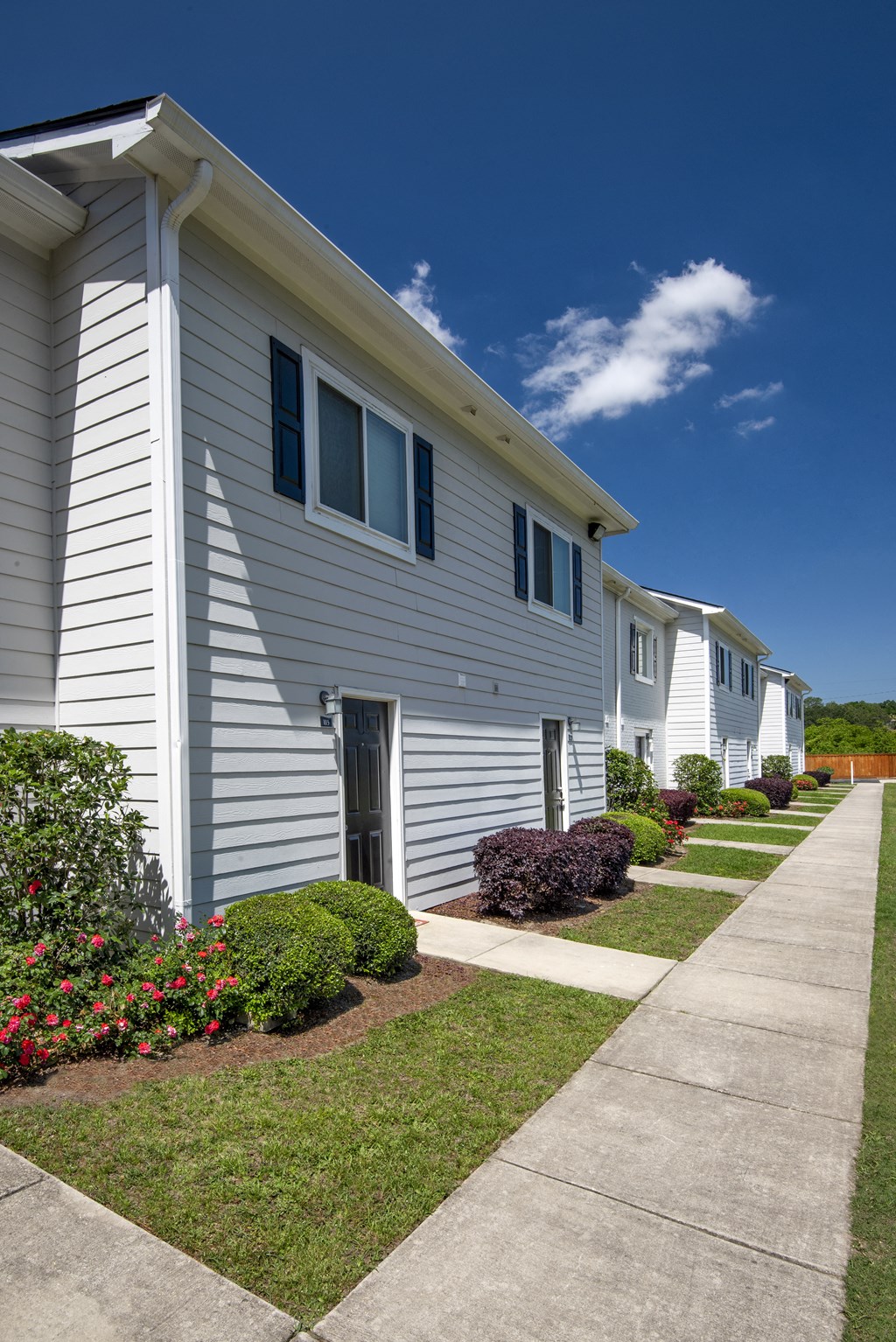 a white house with a sidewalk in front of it