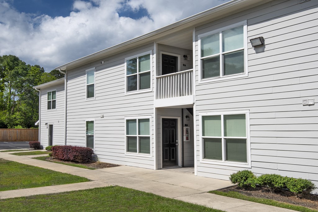 a white house with a sidewalk in front of it