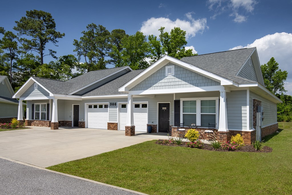 a white house with a driveway and a lawn