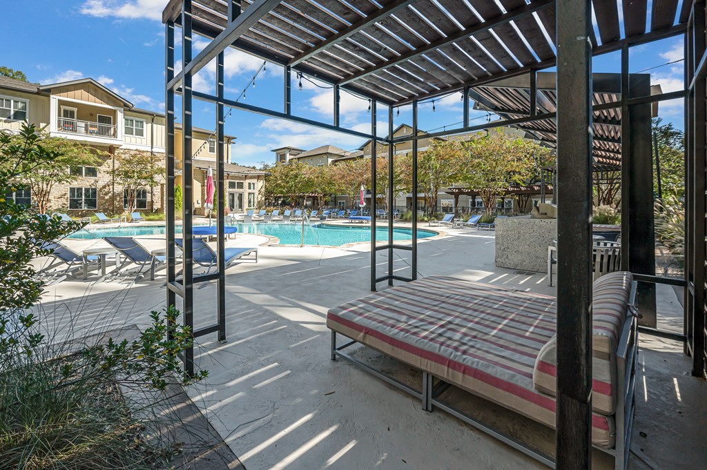 A pool area with a bench and a pool.