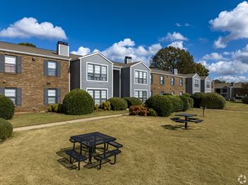 A sunny day at a residential area with a picnic table in the foreground.