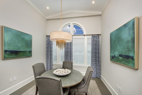a dining room with a table and chairs and a window